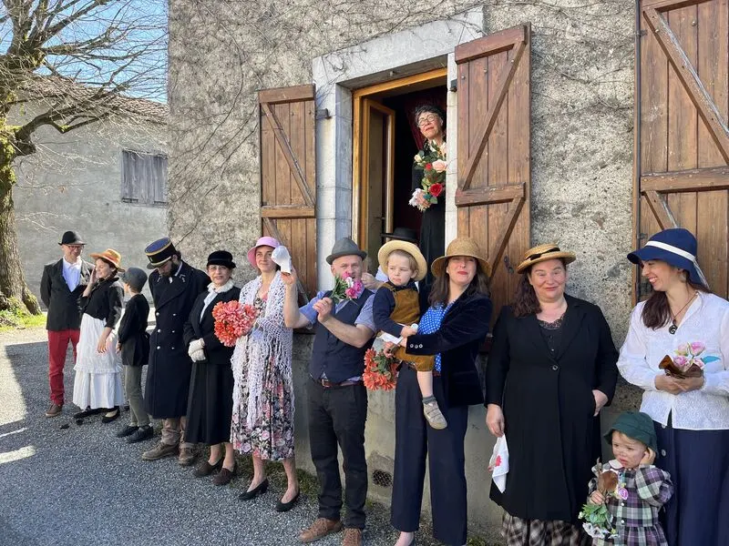 Une dizaine de personnes en costumes d’époque alignées dans une rue du village