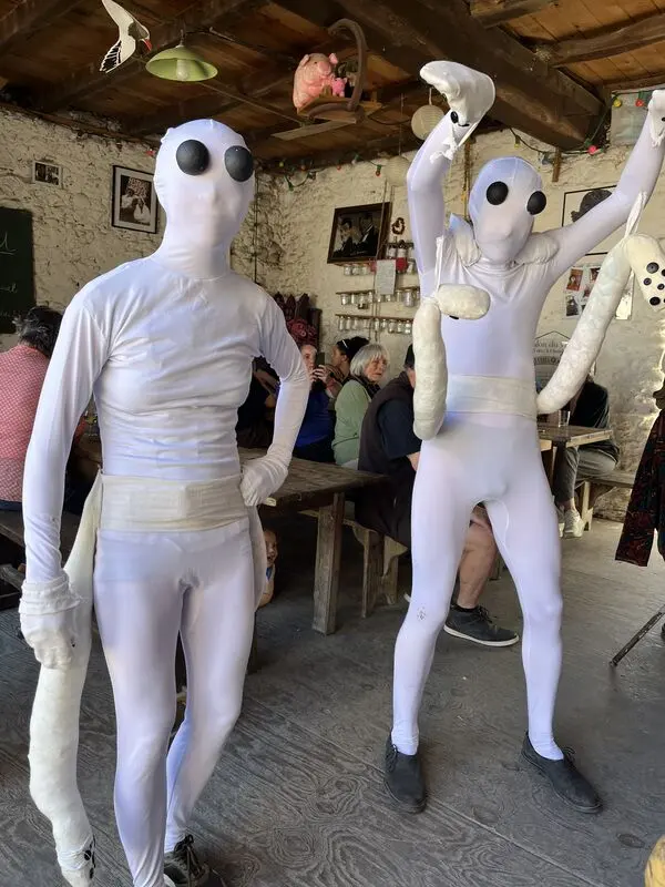 Deux performeurs en combinaison blanche dans la salle du Café
